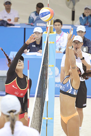 ◎ 十一月四日,曹舒婷(左)扣球。在香港舉行的第十五屆全國運動會沙灘排球女子小組賽E組比賽中,山東隊組合曹舒婷/董頡二比0戰勝澳門隊組合梁安盈/羅詠心。(新華社發盧炳輝攝)