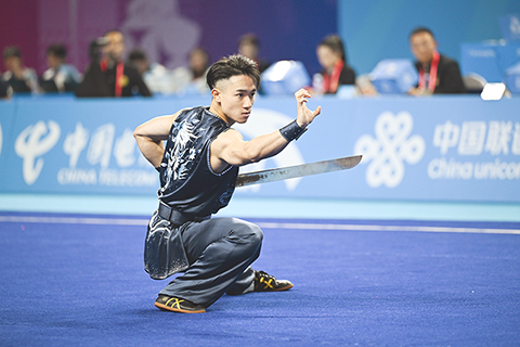 ◎ 十一月七日,在廣州南沙體育館舉行的全運武術套路男子南拳南刀南棍全能比賽中,北京體育大學選手李劍鳴奪得金牌,雲南選手余迪昊獲得銀牌,廣東選手楊富華獲得銅牌。圖為澳門選手陳子傲在南刀比賽中。(中新社記者 陳楚紅 攝)