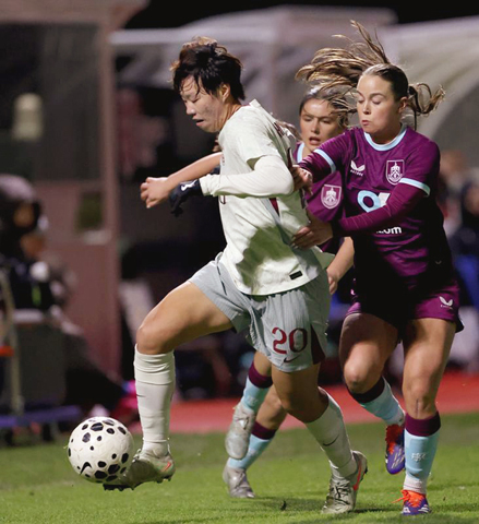 ◎ 十一月二十四日,中國隊球員邵子欽(左)帶球進攻。在英國特倫特河畔伯頓的英格蘭足球訓練中心舉行的一場熱身賽中,中國女足二比0戰勝伯恩利女足。(新華社記者 李穎 攝)