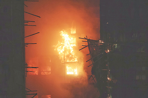 ◎ 十一月二十六日,香港大埔宏福苑發生五級火警,宏昌閣外牆棚架率先起火,其後蔓延至宏泰閣及宏新閣等大廈。截至傍晚八時,火警造成最少十三死十五傷,其中兩名傷者情況危殆、一人情況嚴重,一名消防員殉職。(香港中通社記者 謝光磊 攝)