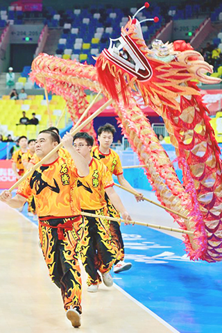 ◎ 十二月九日,演員在開賽儀式上進行舞龍舞獅表演。在廣東佛山舉行的全國第十二屆殘疾人運動會暨第九屆特殊奧林匹克運動會聾人籃球男子組小組賽中,山東隊九十五比五十四戰勝河北隊。(新華社記者 吳青昊 攝)