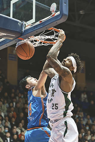 ◎ 十二月二十日,在四川成都舉行的CBA常規賽比賽中,四川豐谷酒業隊主場五十三比八十四負於南京天之藍隊。圖為南京天之藍隊球員所羅門(右)進球。(中新社記者王磊 攝)