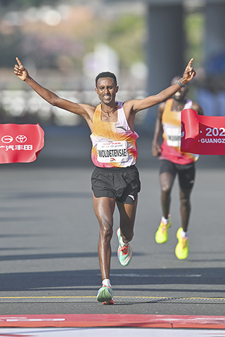 ◎ 十二月二十一日,廣州馬拉松賽鳴槍開跑。本屆賽事起點設在天河體育中心南廣場,終點設在海心沙,賽道沿用「一江兩岸」路線,吸引二萬六千名跑者參賽。圖為埃塞俄比亞選手阿費沃克.梅斯芬沖線奪得男子組冠軍。(中新社記者 陳驥旻 攝)