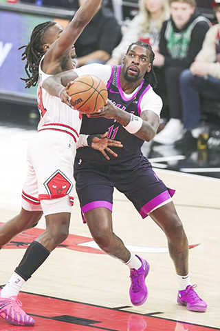 ◎ 木狼隊列特(右)昨役上籃,最終客勝公牛。(新華社發)