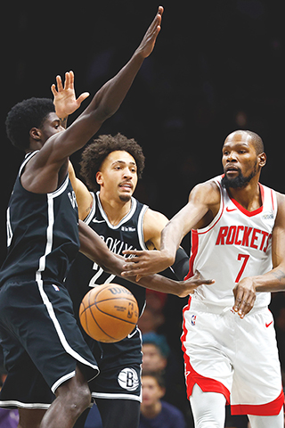 ◎ 二0二六年一月一日於紐約舉行的NBA常規賽下半場,休士頓火箭隊前鋒凱文.杜蘭特(7),對陣布魯克林籃網隊後衛德雷克.鮑威爾及前鋒賈倫.威爾森(中)並傳球。(美聯社)