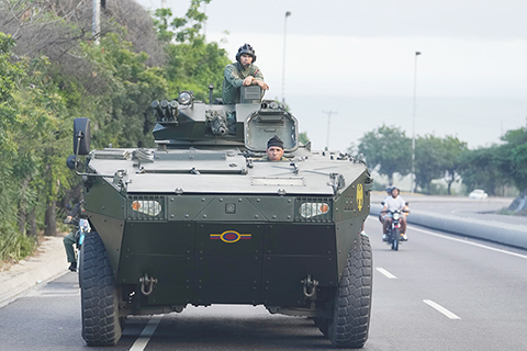 ◎一月四日,一名士兵站在一輛裝甲車頂,在從國際機場通往委內瑞拉加拉加斯的公路上行駛。(美聯社照片/Matias Delacroix)