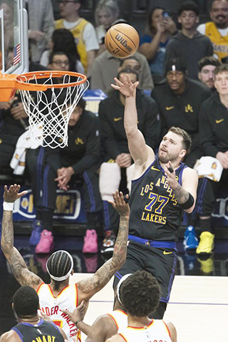 ◎ 一月十三日,湖人隊球員當錫(上)投籃。洛杉磯湖人隊主場一百四十一比一百一十六戰勝阿特蘭大老鷹隊。(新華社發 趙漢榮攝)