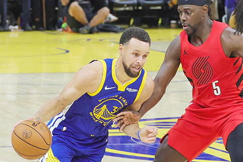 ◎ 一月十三日,勇士隊球員居里(左)進攻。金州勇士隊主場一百一十九比九十七戰勝波特蘭拓荒者隊。(新華社發 董旭東攝)