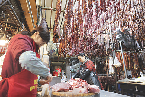◎一月二十一日,四川省成都市新開寺街一家肉舖工作人員忙著手工製作香腸。中國農曆春節將至,有著「香腸一條街」之稱的新開寺街各家肉舖逐漸忙碌起來,臘肉、香腸飄香整條街道。(中新社記者 張浪 攝)