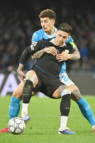 ◎ 1月28日,拿玻里隊迪羅倫素(後)與車路士隊安素費南迪斯拼搶。(新華社發)