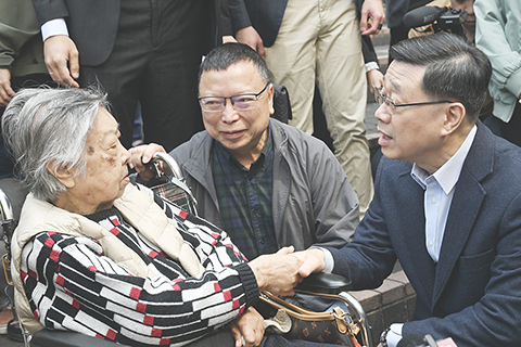 ◎ 二月十三日,香港特區行政長官李家超到油麻地駿發花園,探訪住戶及長者社區服務中心,了解市民的生活情況。圖為李家超(右一)慰問長者。(中新社記者 李志華 攝)