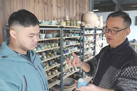 ◎ 二0二六年春節,成都彭州海窩子古鎮,蔡兆慶與兒子在討論陶瓷工藝。(中新社記者 呂楊 攝)