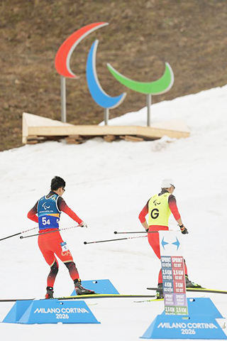 ◎ 3月14日,中國隊選手余爽與引導員尚金財(右)在比賽中。當地時間3月14日,在意大利泰塞羅舉行的米蘭-科爾蒂納冬殘奧會越野滑雪公開接力4×2.5公里比賽中,中國隊奪得冠軍。(新華社記者侯昭康 攝)