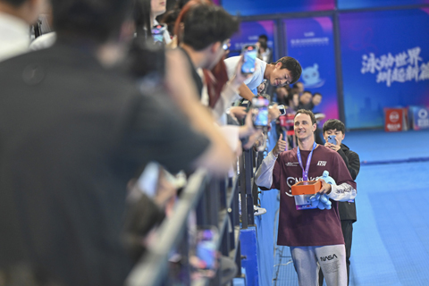 ◎ 3月20日晚,2026年中國游泳公開賽暨全國春季游泳錦標賽在廣東深圳進入第二個比賽日。在男子50米自由泳決賽中,澳大利亞名將卡梅倫.麥克沃伊以20.88秒刷新世界紀錄,奪得冠軍。圖為卡梅倫.麥克沃伊完賽後與觀眾合影。(中新社記者陳驥旻 攝)