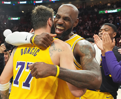 ◎ 湖人七十七號當錫和占士相擁,他們昨役各自創出佳績,打敗熱火。(美聯社)