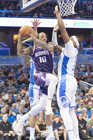 ◎ 三月二十六日在佛羅里達州奧蘭多舉行的NBA常規賽上半場,薩克拉門托帝王隊後衛/前鋒德瑪爾.迪羅辛(10)在籃下與奧蘭多魔術隊中鋒/前鋒小溫德爾.卡特(34)對決。(美聯社/Willie J. Allen Jr.)