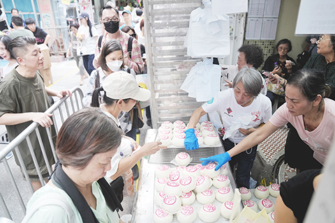 ◎ 五月廿四日,一年一度的香港長洲太平清醮活動舉行,民眾在長洲島的一家包點店購買平安包。平安包是長洲太平清醮的標誌性特色食品,寓意「平安健康」。(中新社記者張祥毅 攝)