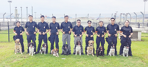 ◎ 這是機場保安犬隻行動小組部份領犬員和犬隻合照(六月八日攝)。(新華社發 香港機場管理局供圖)
