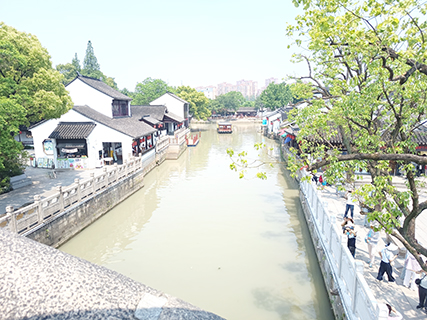站在寒山寺旁的小橋上眺望河岸景色
