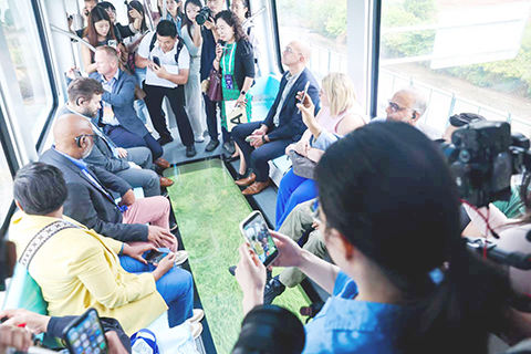 9月19日,外國嘉賓體驗乘坐光子號空軌列車。(張暢 攝)
